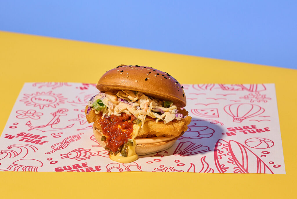 Chilli Cheese Fish Sandwich Burger from YOMG ~ golden crumbed fresh fish, cheese sauce, chilli sauce, jalapenos, slaw, lemon sriracha mayo #yomgitsHOT