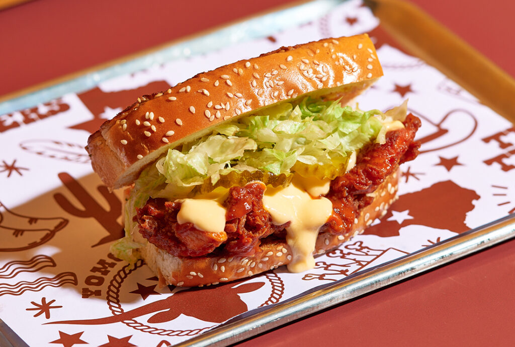 Buffalo Texan Toast #YOMGlimited Menu by YOMG ~ crunchy chicken texan tender, franks buffalo sauce, shredded iceberg lettuce, cheese sauce, bread & butter pickles #yomgitsHOT