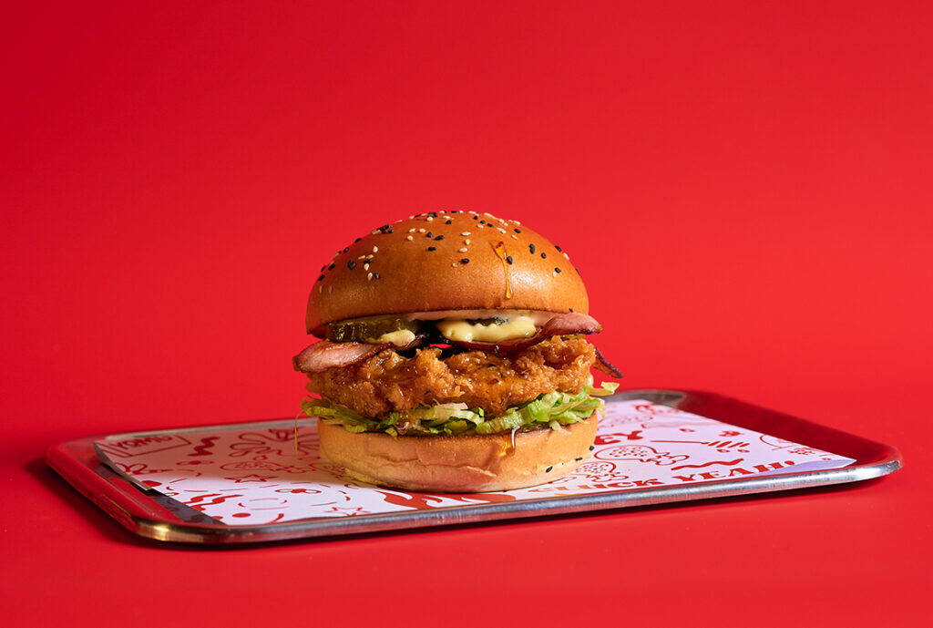 Hot Honey Buk Burger ~ hot honey crunch chick'n, bacon, shredded iceberg lettuce, bread & butter pickles, onion jalapeno jam, honey mustard mayo, ranch